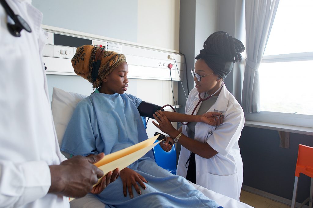 An African young Female Doctor taking blood pressure on a young patient with a headscarf Cape Town South Africa