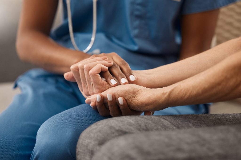 Doctor holding a patient's hand to be reassuring